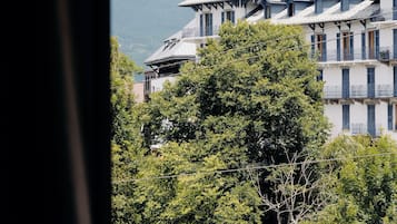 Un edificio con varios balcones y montañas al fondo.