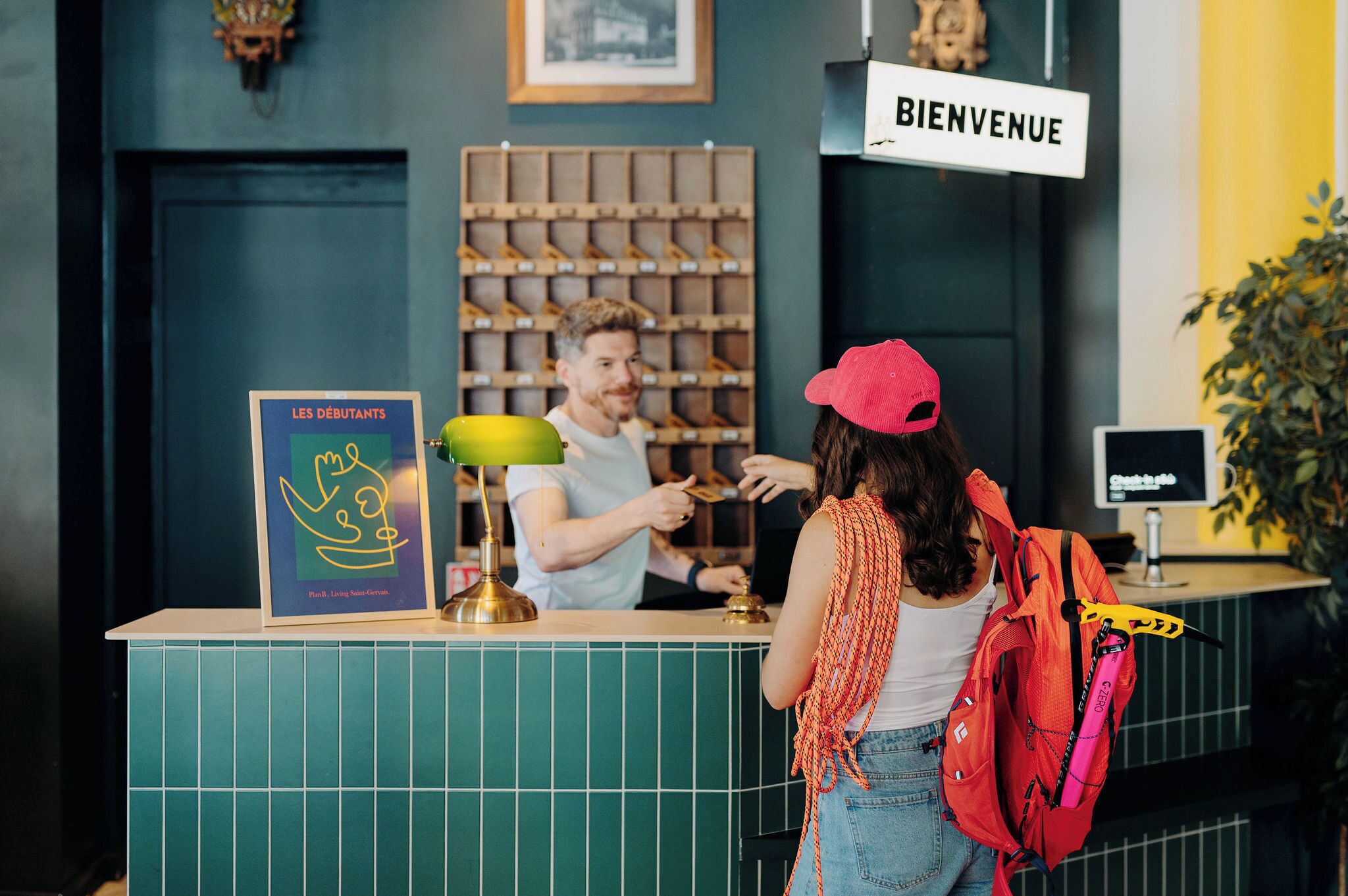A reception desk with a 'BIENVENUE' sign, a framed welcome sign, and a wall with a shelf of items.