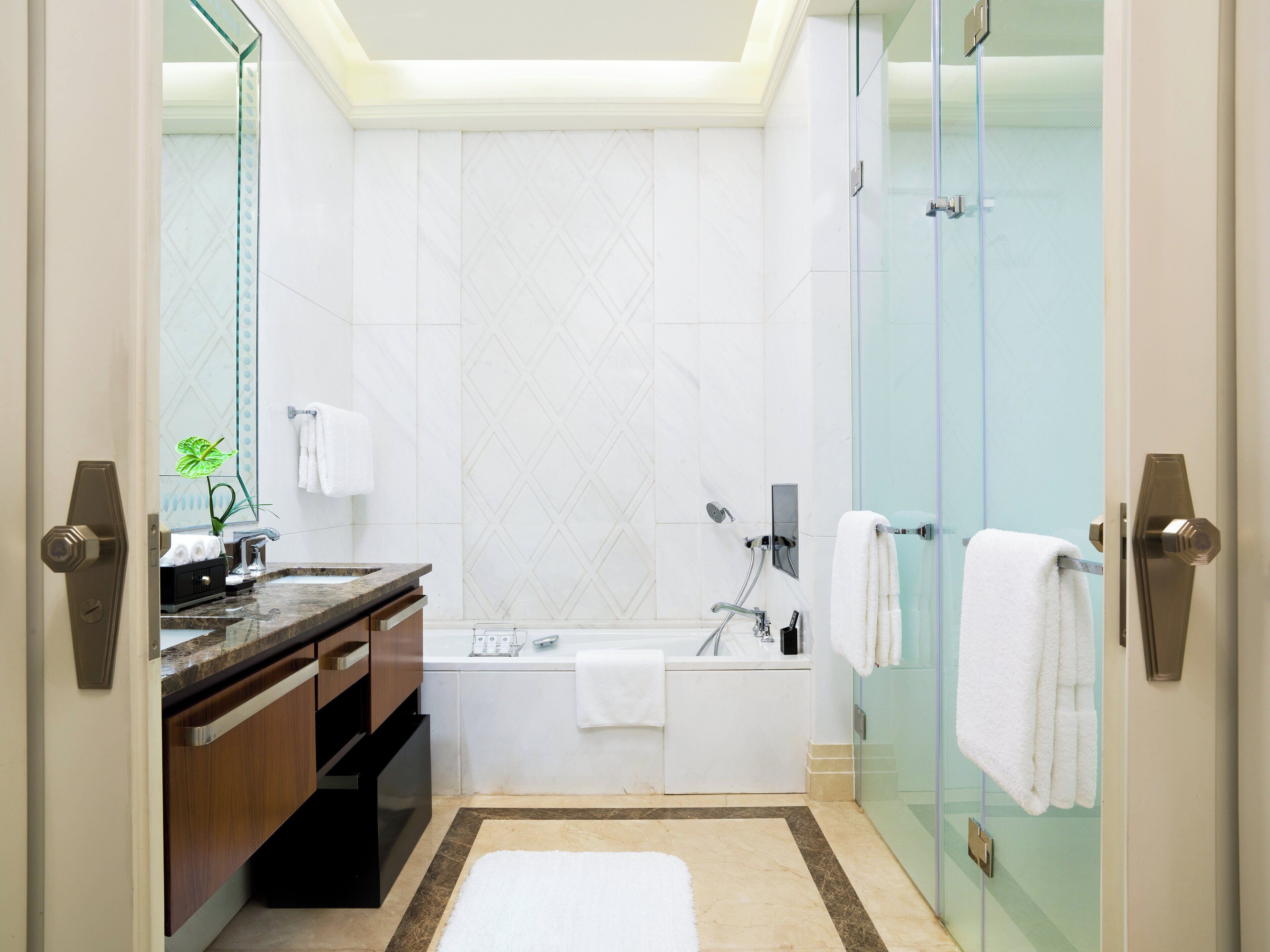 Un baño moderno con bañera, cabina de ducha de vidrio y tocador con lavabo y espejo.