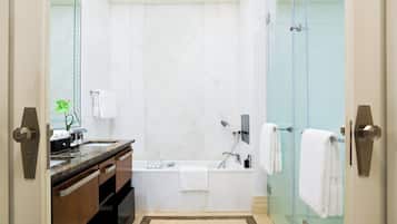 Un baño moderno con bañera, cabina de ducha de vidrio y tocador con lavabo y espejo.