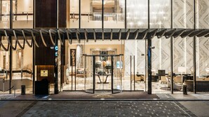 A hotel entrance with a glass facade, a reception area, and a chandelier. - The St. Regis Chengdu (Chengdu)