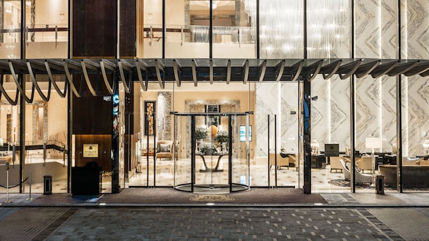 A hotel entrance with a glass facade, a reception area, and a chandelier. - The St. Regis Chengdu (Chengdu)