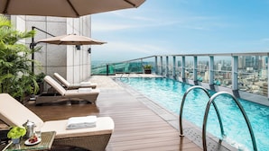 A rooftop infinity pool with lounge chairs and umbrellas, overlooking a cityscape. - The St. Regis Chengdu (Chengdu)