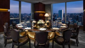 A modern dining room with a panoramic city view, a round table set for six, and a unique ceiling design. - The St. Regis Chengdu (Chengdu)