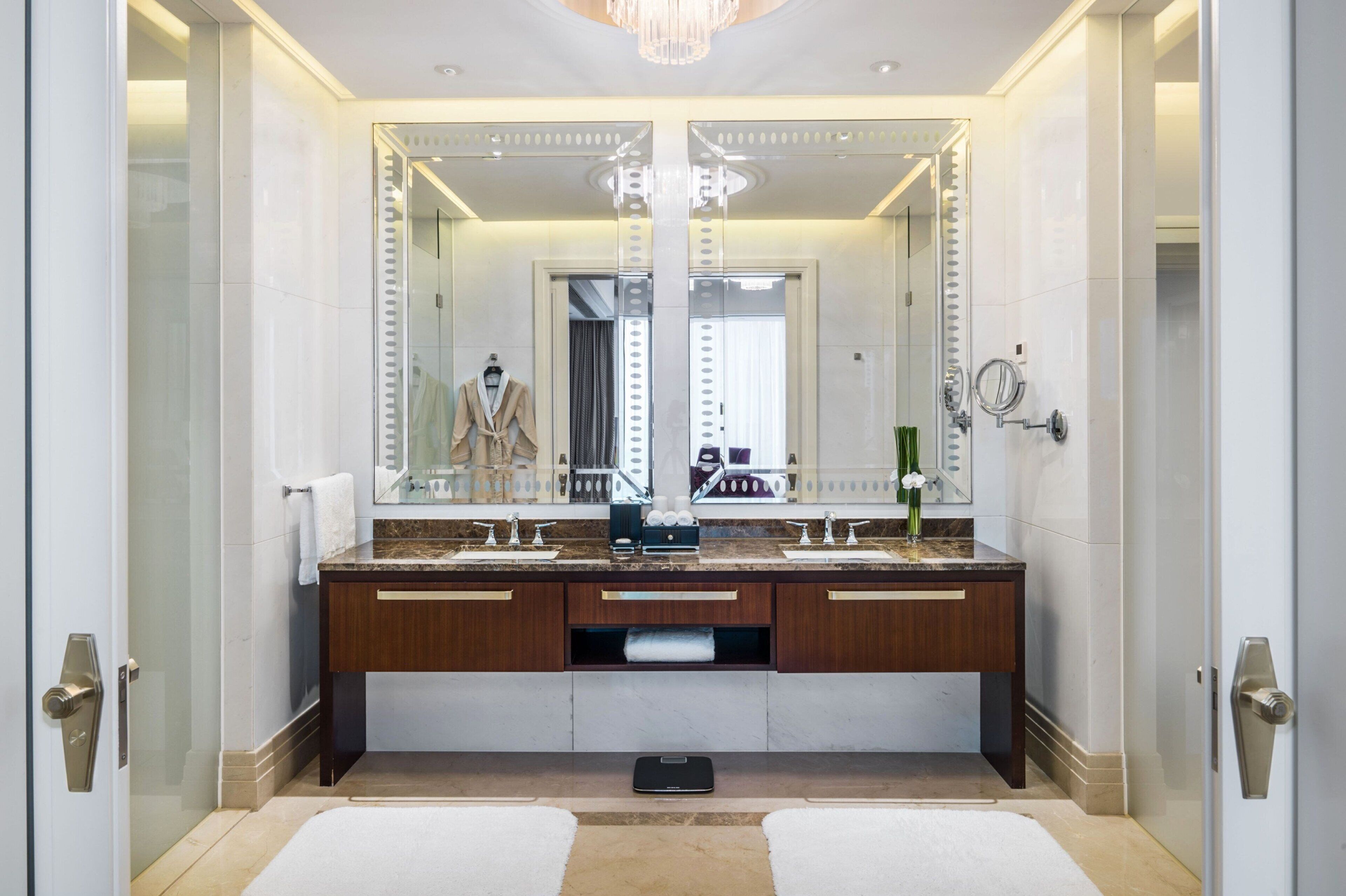 A modern bathroom with a large mirror, dual sinks, and a vanity.