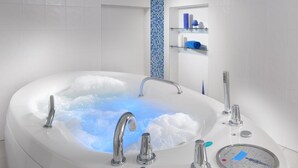 A modern bathroom with a large bathtub, chrome fixtures, and a built-in showerhead. - Hotel Reza (Frantiskovy Lazne)