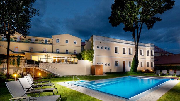 A swimming pool with lounge chairs and a staircase leading to a building. - Hotel Reza (Frantiskovy Lazne)