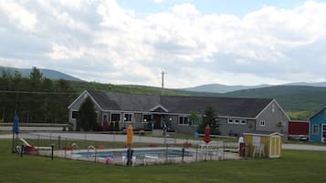 A building with a swimming pool, a fenced area, and a small shed.