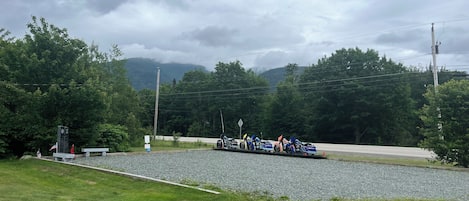 A gravel area with a row of motorcycles parked.