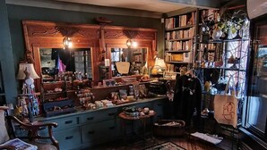 Une pièce chaleureuse avec un grand miroir, des meubles en bois, une bibliothèque et un tapis à motifs.
