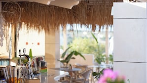 A bar area with a counter, utensils, and a refrigerator. - Dia Apartments (Hersonissos)