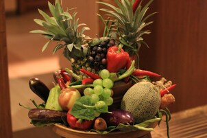 Un tazón con frutas y verduras variadas, incluyendo piña, pimiento rojo, uvas y melón.