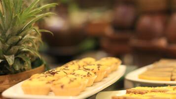 Una mesa de buffet con varios postres, incluyendo cupcakes y una piña.