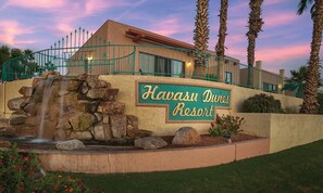Señal del Resort Havasu Dunes con una cascada de piedra al frente.