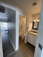 Uma casa de banho moderna com chuveiro, sanita e lavatório.