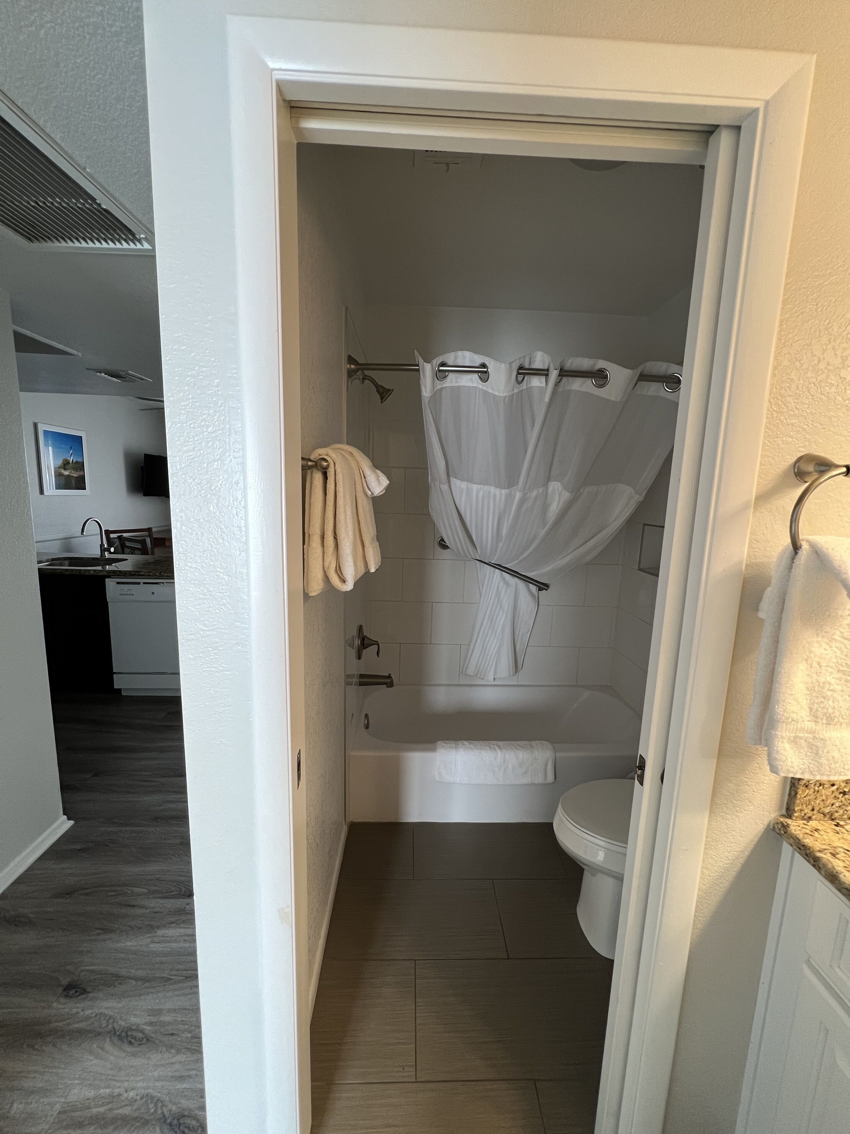 A bathroom with a bathtub, toilet, and shower curtain.