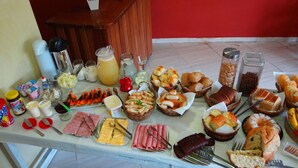 A buffet table with various food items and beverages. - Recanto Tropical Hotel (Guarujá)