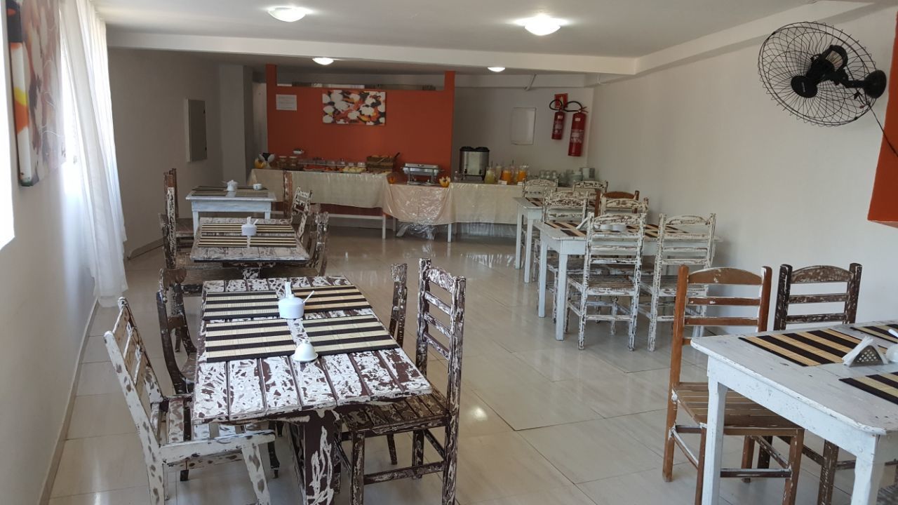 A dining area with rustic wooden tables and chairs, a buffet setup, and a fire extinguisher on the wall.