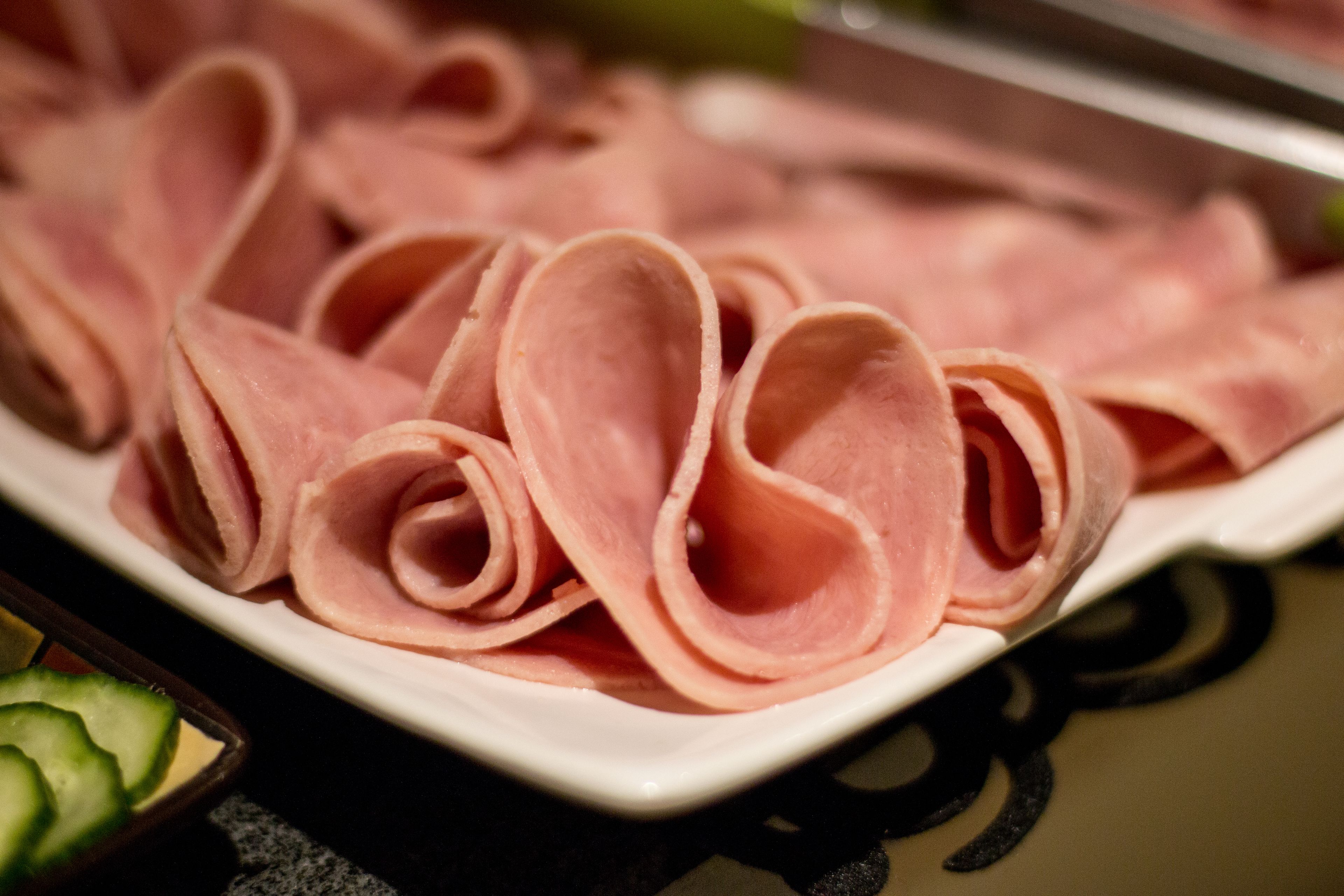 A plate of sliced ham arranged in a decorative pattern.