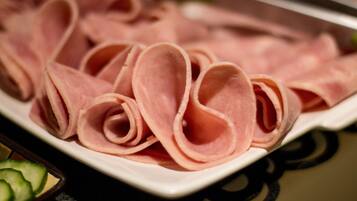 A plate of sliced ham arranged in a decorative pattern.