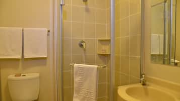 A bathroom with a toilet, a shower, and a sink.