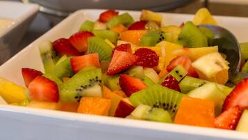 A bowl of mixed fruit salad with strawberries, kiwi, pineapple, and melon.