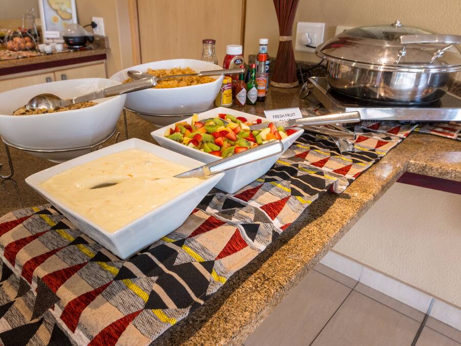 A buffet setup with various food items and serving utensils.