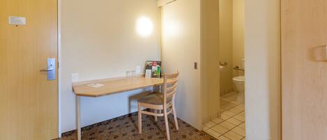 A small room with a desk, chair, and a door.