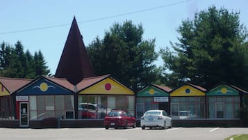A row of colorful buildings with a restaurant, a motel office, and a vacant sign.