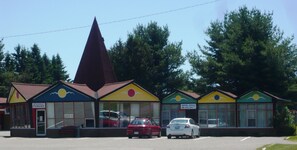 A row of colorful buildings with a restaurant, a motel office, and a vacant sign.