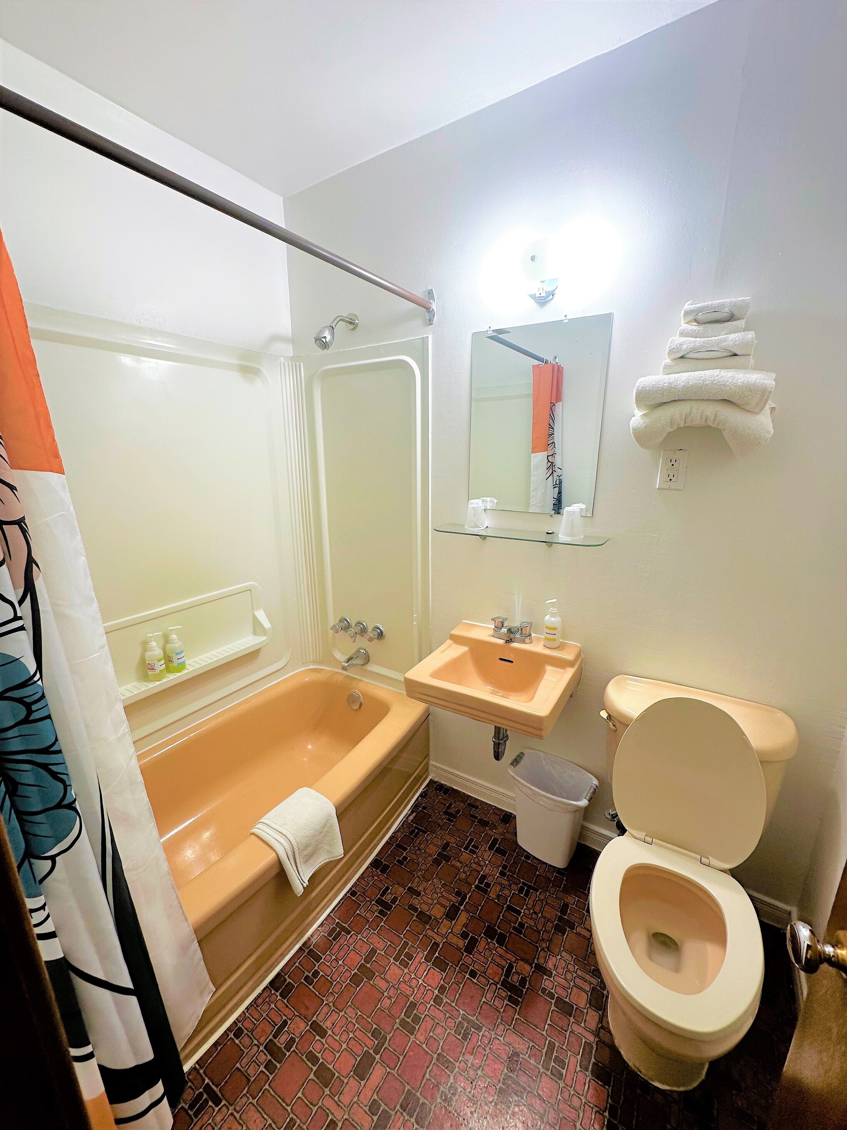 Une salle de bain avec une baignoire, un lavabo, des toilettes et un miroir.