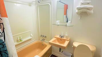 Une salle de bain avec une baignoire, un lavabo, des toilettes et un miroir.
