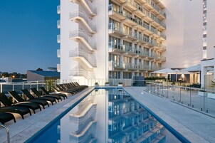 Una piscina al aire libre, sillones reclinables de piscina