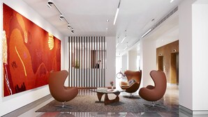 A modern lobby with a large abstract painting, two leather armchairs, a glass coffee table, and a striped partition. - Art Series - The Watson (Walkerville)