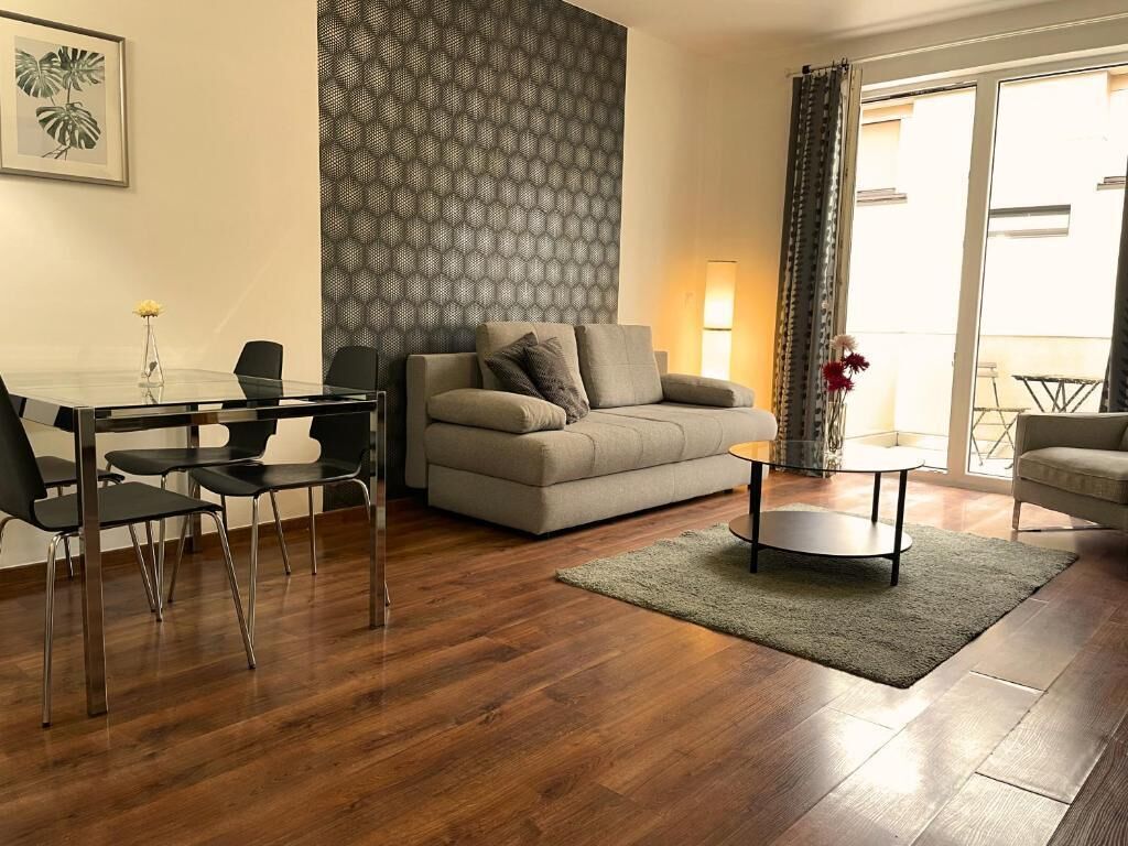 Una sala de estar con sofá, una mesa de centro y un comedor con sillas y una mesa.