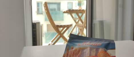 A package of Original's chicken breast strips on a table with a rope and a window view of a building.