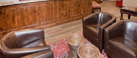 A lobby with wooden paneling, leather seating, and a reception desk.