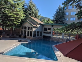 Una piscina al aire libre, sombrillas, tumbonas