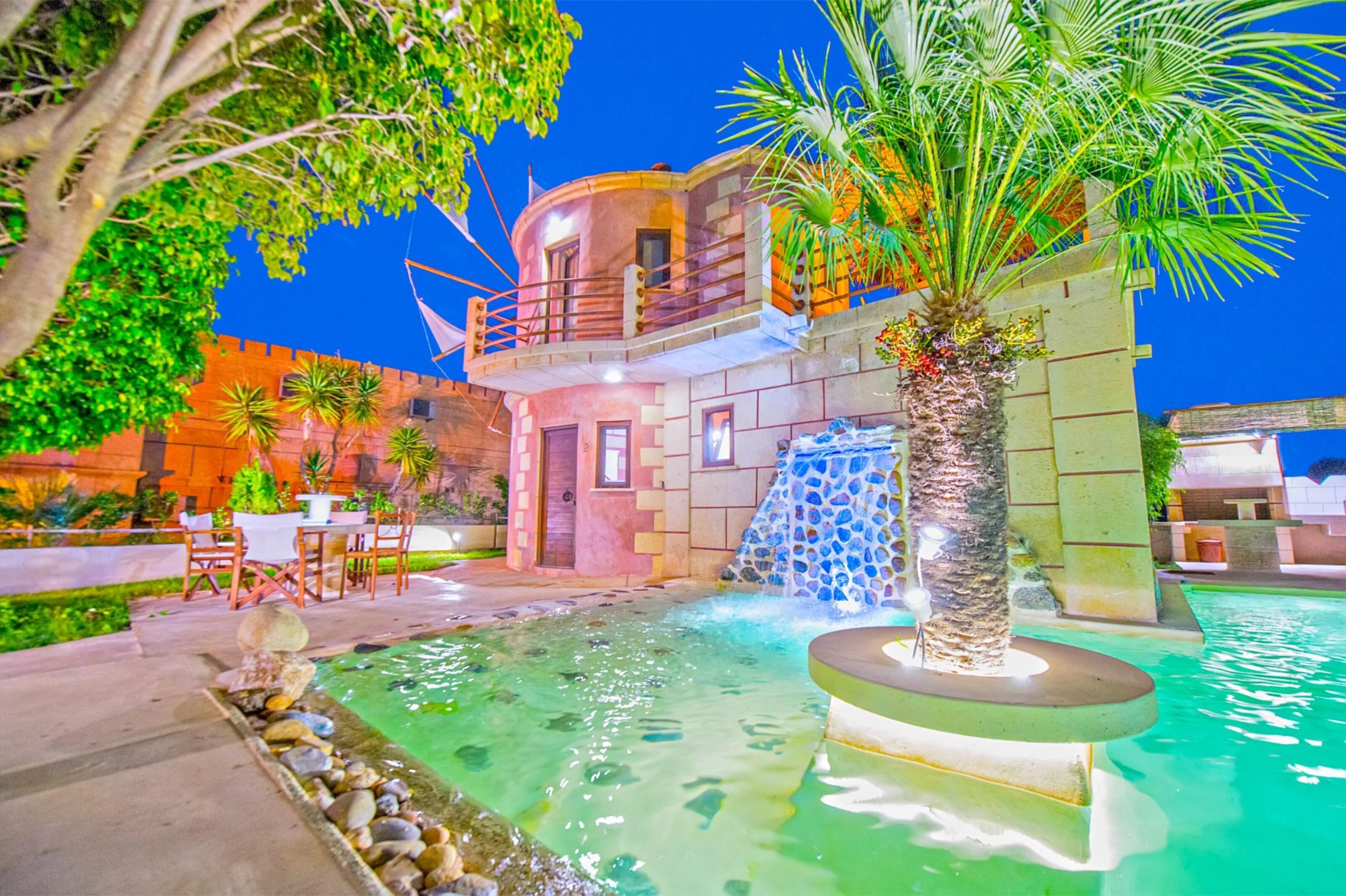 Un hôtel doté d’une piscine, d’un espace extérieur aménagé et d’une cascade décorative.
