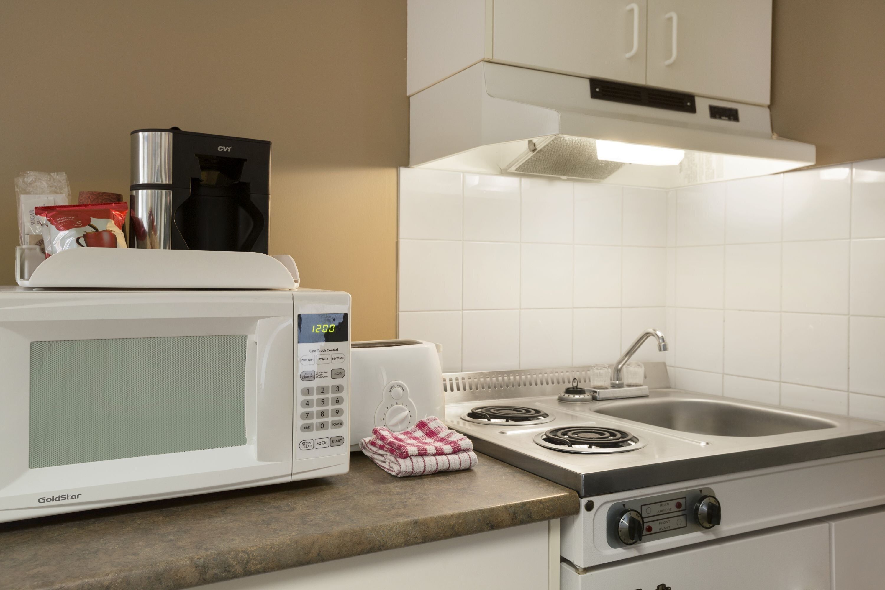 Una cocina equipada con microondas, tostadora, estufa y lavaplatos.