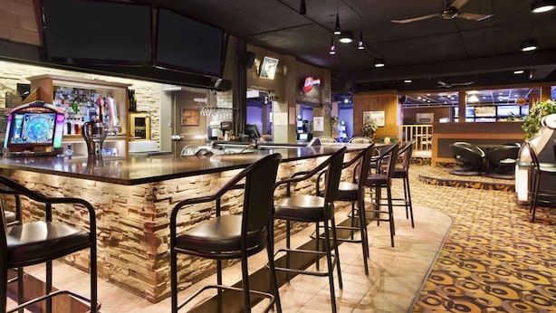 A bar area with a counter, stools, and a jukebox.