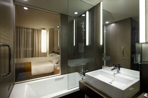 Ein modernes Badezimmer mit einer gläsernen Dusche, einer großzügigen Badewanne und einem Doppelwaschbecken.