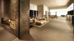 Un intérieur moderne avec une cheminée, un coin salon et une cuisine en arrière-plan.