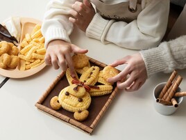 Una persona organizando galletas en una bandeja.