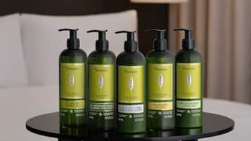 A set of five green bottles of Vervine products on a round table.