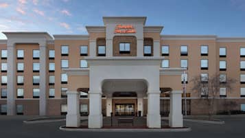 Hampton Inn & Suites features a symmetrical facade with a central entrance and columns.