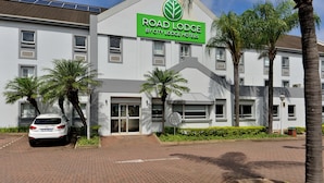 Hotel amb un cartell que diu "ROAD LODGE BY CITY LODGE HOTELS" i panells solars a la teulada.