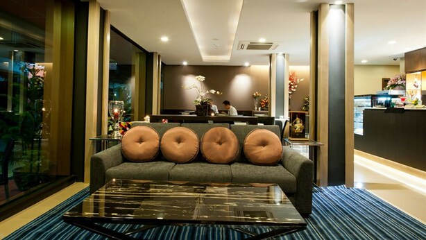 A modern hotel lobby with a sofa, a glass coffee table, and a reception desk. - 41 Suite Bangkok (Bangkok)