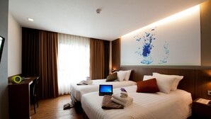 A hotel room with two beds, a desk, a laptop, and a wall-mounted TV. - 41 Suite Bangkok (Bangkok)