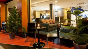 A lobby with a sofa, chairs, and potted plants. - 41 Suite Bangkok (Bangkok)